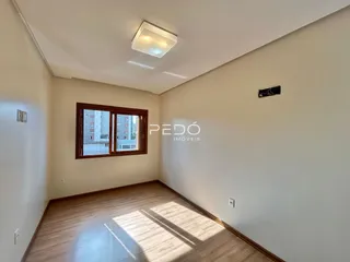 Sala de estar com piso de madeira e janela em um imóvel no Brasil.