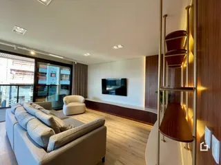 Sala de estar moderna com sofá e piso de madeira clara.