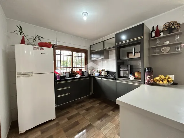 Foto da cozinha de uma residência com armários escuros e piso de madeira.