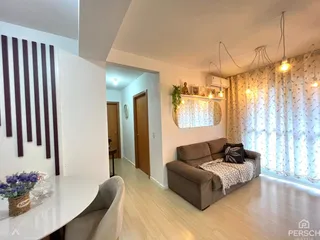 Sala de estar com sofá e piso de madeira clara em um apartamento em Lajeado.