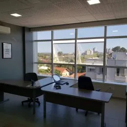 Sala com grandes janelas que proporcionam uma vista da paisagem externa.