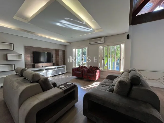 Sala de estar com dois sofás grandes e piso de madeira.