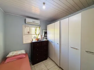 Quarto com armários e cama em um ambiente claro.