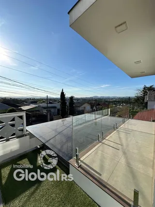 Vista aérea de uma área externa com piso de concreto e grade de vidro.