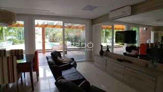 Sala de estar com portas de vidro que dão acesso ao jardim.