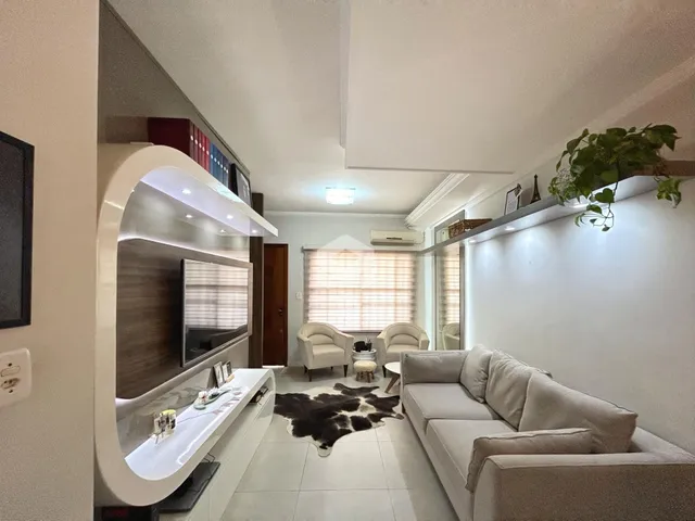 Sala de estar com sofá e televisão em um apartamento no Brasil.