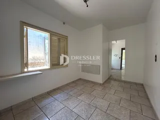 Vista interna de uma sala com piso de cerâmica e janela.