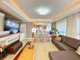 Sala de estar moderna com sofá e televisão em um ambiente bem iluminado.