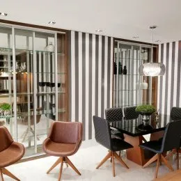 Sala de estar com paredes listradas e portas de vidro.