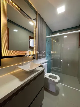 Foto de um banheiro moderno com box de vidro e louças sanitárias.
