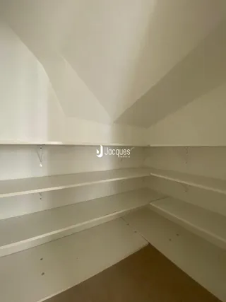 Vista de um corredor com prateleiras embutidas em um imóvel.
