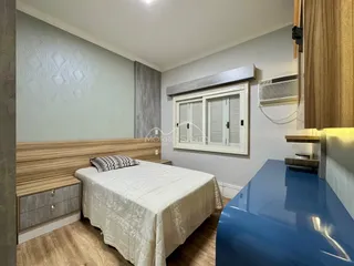 Quarto com cama de casal e cabeceira de madeira.