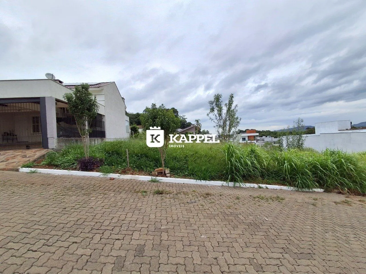 Fachada de uma residência em Lajeado, Brasil, com área externa pavimentada.