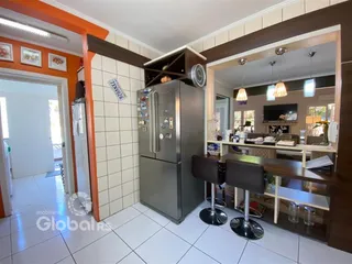 Ambiente interno de uma sala de estar com revestimento de cerâmica e móveis de aço inoxidável.
