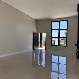 Sala ampla com piso claro e grande janela.