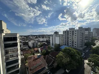 Vista aérea de um bairro residencial em Lajeado, Brasil, com edifícios e vegetação.