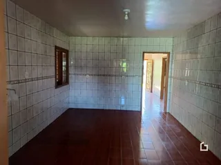Corredor interno com piso e paredes revestidos de cerâmica.