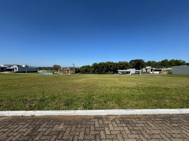Vista externa de um terreno gramado sob um céu azul claro.