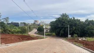 Vista da entrada de uma propriedade com terra e vegetação ao redor.