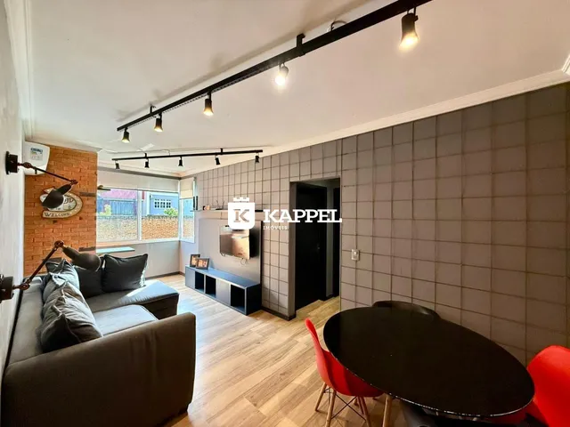 Sala de estar com sofá e mesa de jantar em um apartamento.