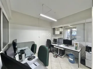 Ambiente de escritório com mesas e cadeiras em um imóvel no Brasil.