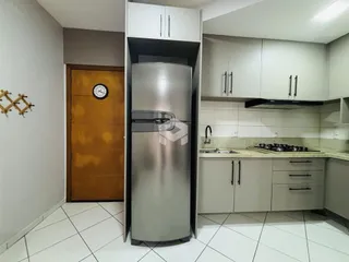 Foto de uma cozinha moderna com armários brancos e geladeira inoxidável.