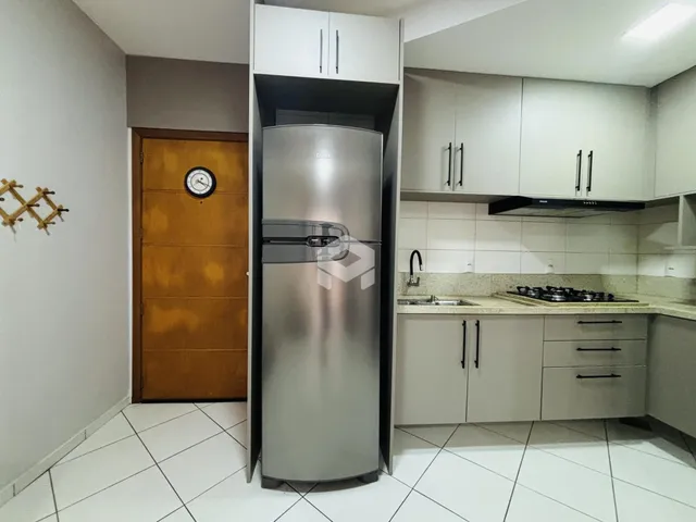 Foto de uma cozinha moderna com armários brancos e geladeira inoxidável.