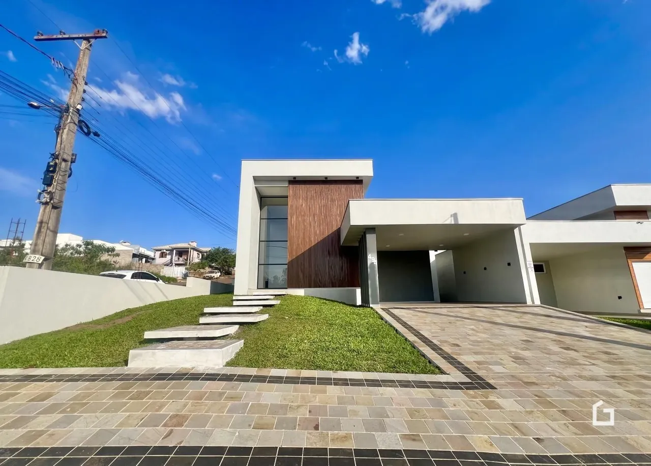 Fachada moderna de uma residência em Lajeado com paisagismo e área pavimentada.