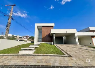 Fachada moderna de uma residência em Lajeado com paisagismo e área pavimentada.