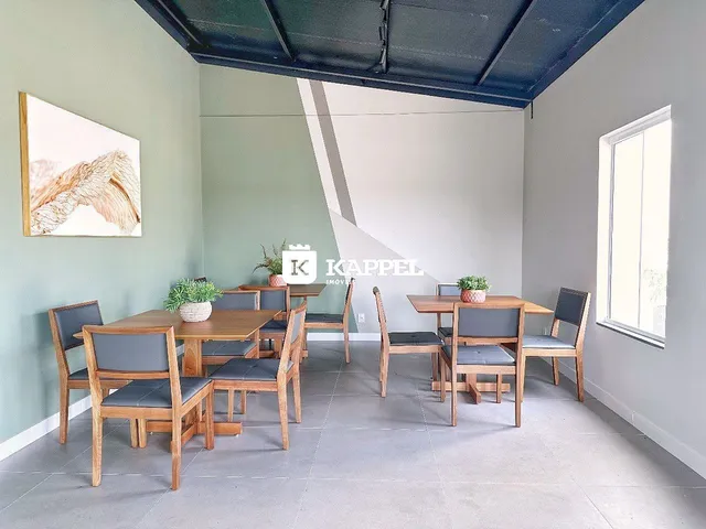 Sala de jantar com mesa de madeira e cadeiras em um ambiente claro.