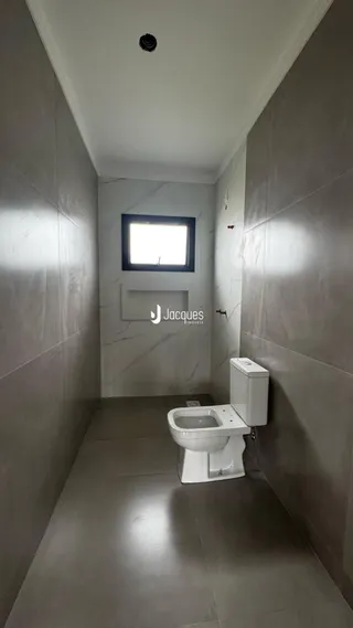 Corredor com janela e vaso sanitário em um imóvel no Brasil.