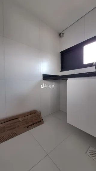 Interior de um ambiente com piso de cerâmica e paredes brancas.