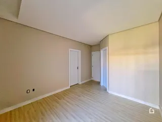 Hall de entrada com portas brancas e piso de madeira clara.