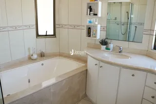 Foto de um banheiro com banheira e revestimento cerâmico.