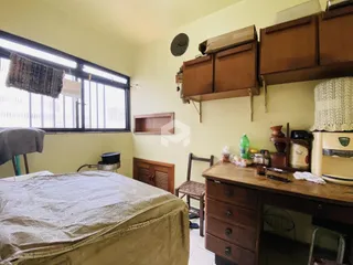 Quarto com janela grande e armários de madeira em Lajeado.