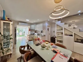 Vista de uma sala de jantar com móveis de madeira clara e decoração moderna.