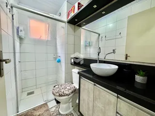 Foto de um banheiro com box de vidro e pia.