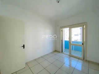 A sala apresenta paredes brancas e piso de cerâmica com porta de vidro.