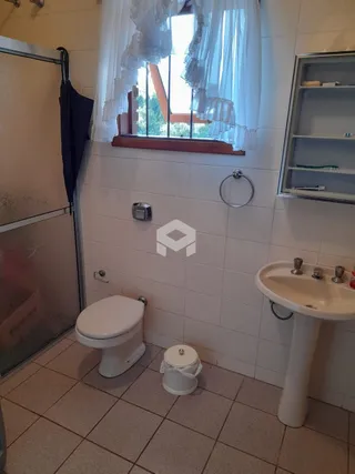 Foto de um banheiro com piso cerâmico e paredes brancas.
