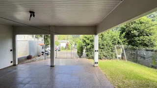 Área externa pavimentada com piso de cerâmica e gramado.