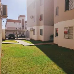 Área externa gramada com vista para o prédio residencial.