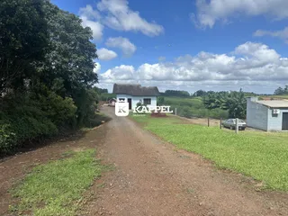 Vista externa de uma casa rural em Lajeado, Brasil, com estrada de terra e vegetação ao redor.