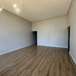 Foto de um ambiente interno com piso de madeira clara.