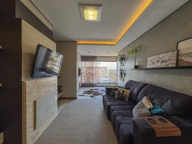 Sala de estar com sofá e televisão em um apartamento no Brasil.