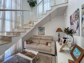 Sala de estar com escadaria e grandes janelas em um imóvel no Brasil.