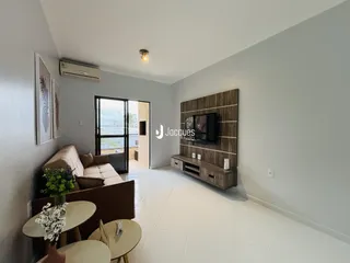 Sala de estar com sofá e painel de TV em apartamento.