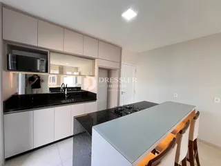 Foto de uma cozinha moderna com armários brancos e bancadas escuras.