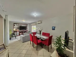 Sala de estar e jantar com sofá e mesa de jantar em um apartamento no Brasil.