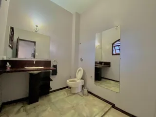 Foto de um banheiro com bancada, pia e vaso sanitário.