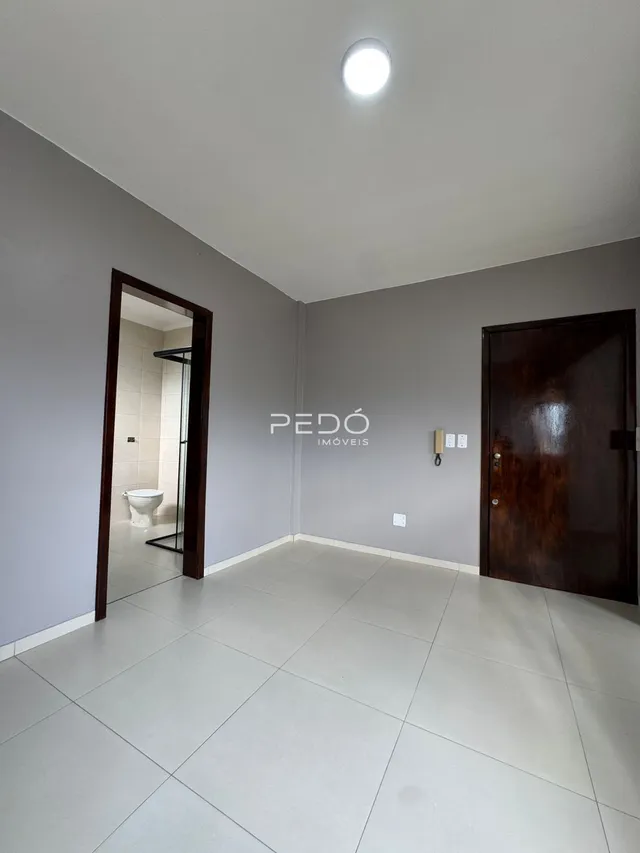 Interior de um ambiente com piso de cerâmica e paredes cinzas.